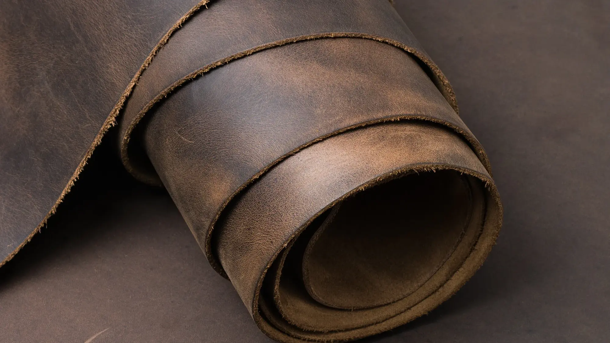 Zwinięty pas brązowej skóry o surowej teksturze